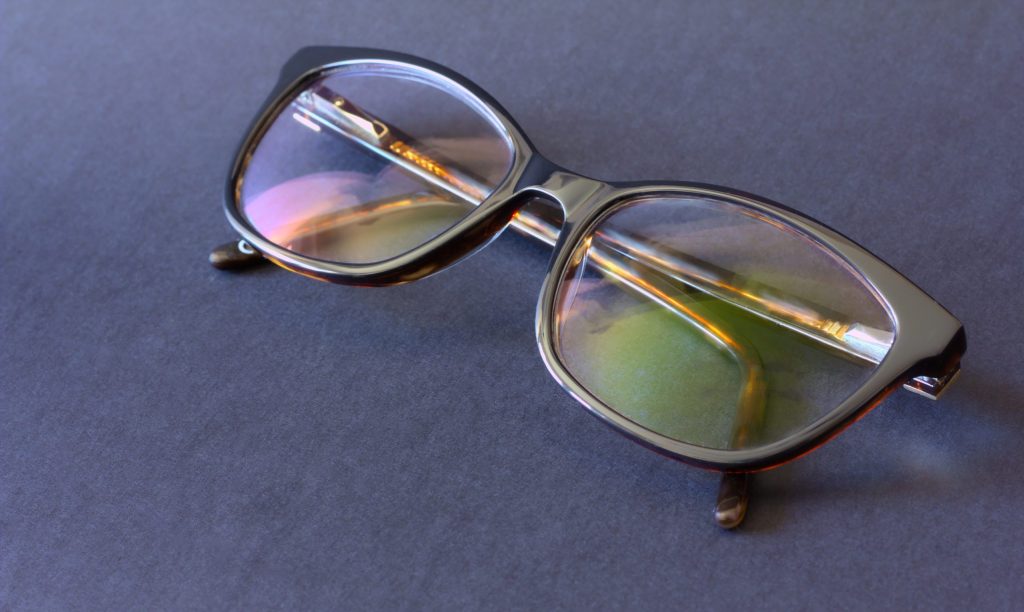 Anti-glare coating on the glasses. Glasses with black frames on a dark background.