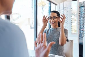 A customer buying, testing or trying on glasses at an optometrist store
