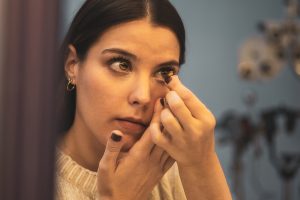 A young girl puts on an animal-patterned contact lens